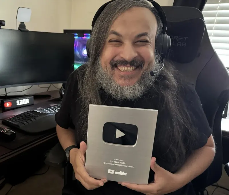 The Silver Play Button — for passing 100,000 subscribers. The counter behind it already says 130K.